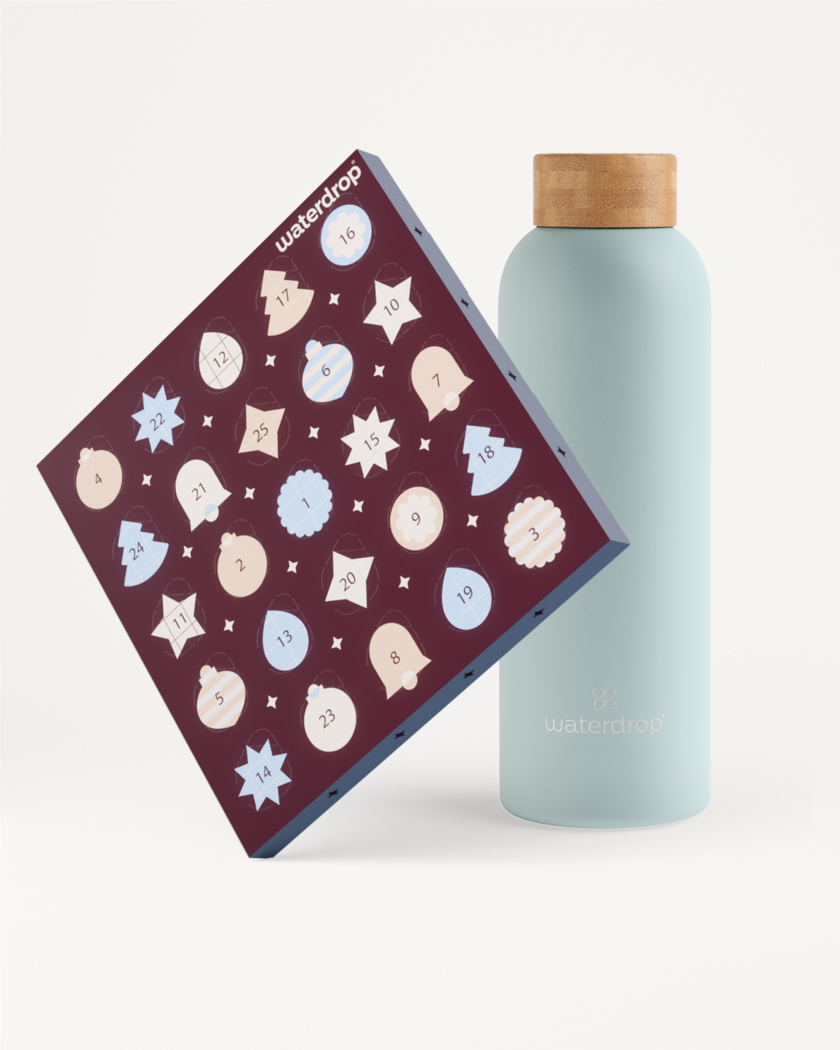 Light blue reusable bottle with a wooden cap beside a purple advent calendar decorated with white and light blue snowflake shapes.