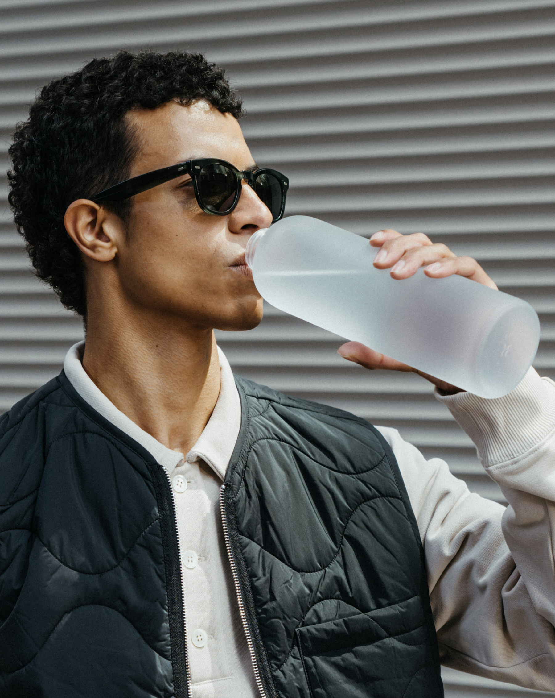 Close-up of a person holding a Frosted Glass bottle, showcasing its timeless design and durable borosilicate glass, perfect for on-the-go refreshments.