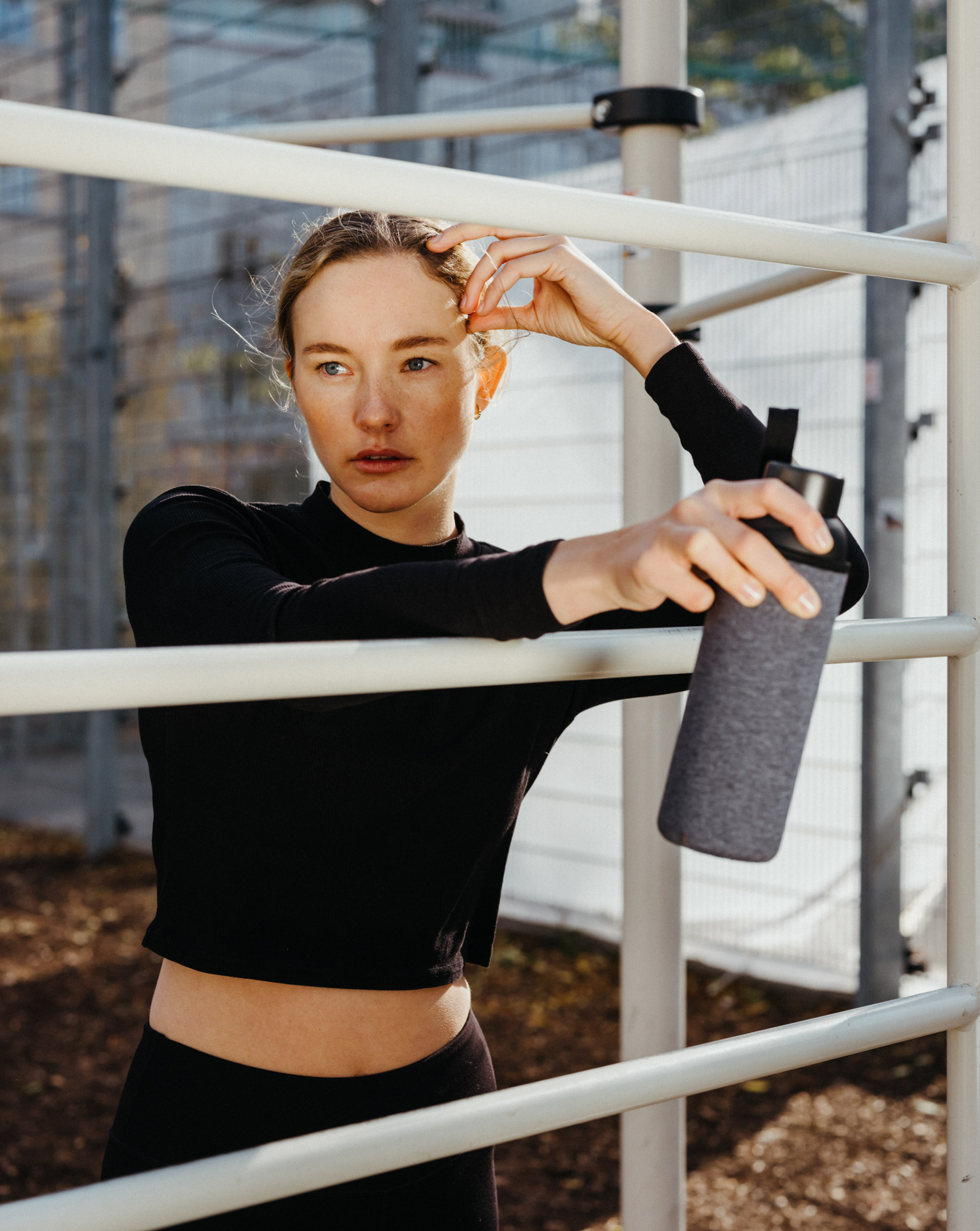 A woman holds a Frosted Glass water bottle, showcasing its timeless, simple design and durable borosilicate construction, perfect for home or on-the-go use.
