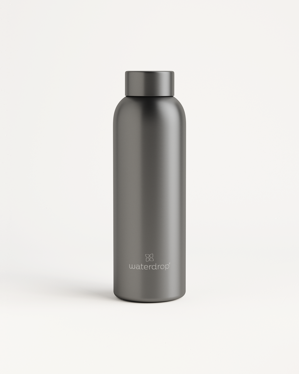 Close-up of the Metal Thermo Steel bottle showing its brushed stainless steel surface and logo designed to keep beverages cold for 24h or hot for 12h.