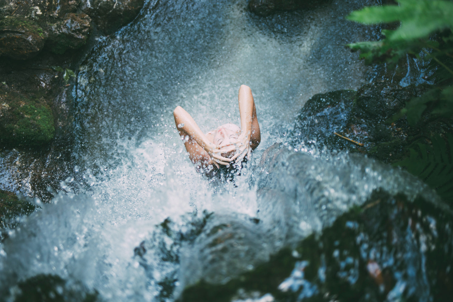 Person from above standing under a waterfall 