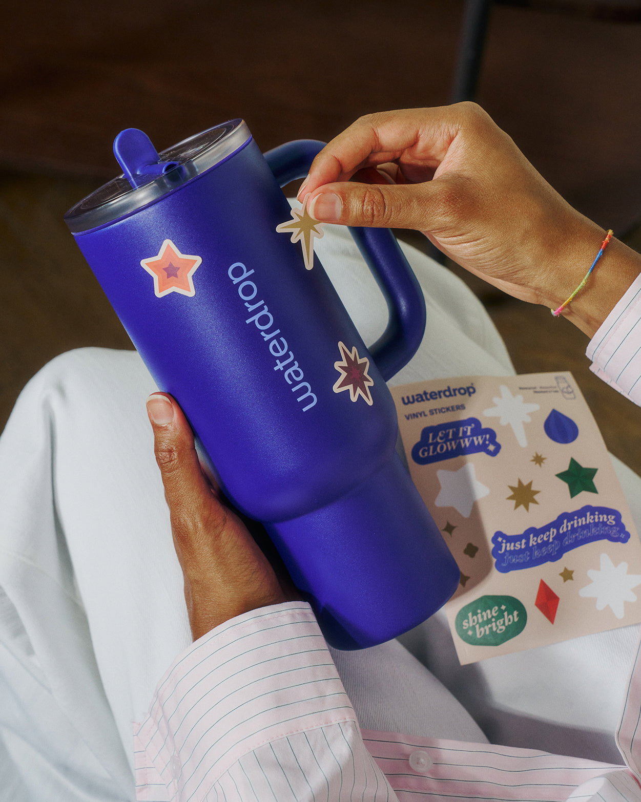 Advent Calendar Large: Person decorates cobalt-blue travel mug with star stickers.