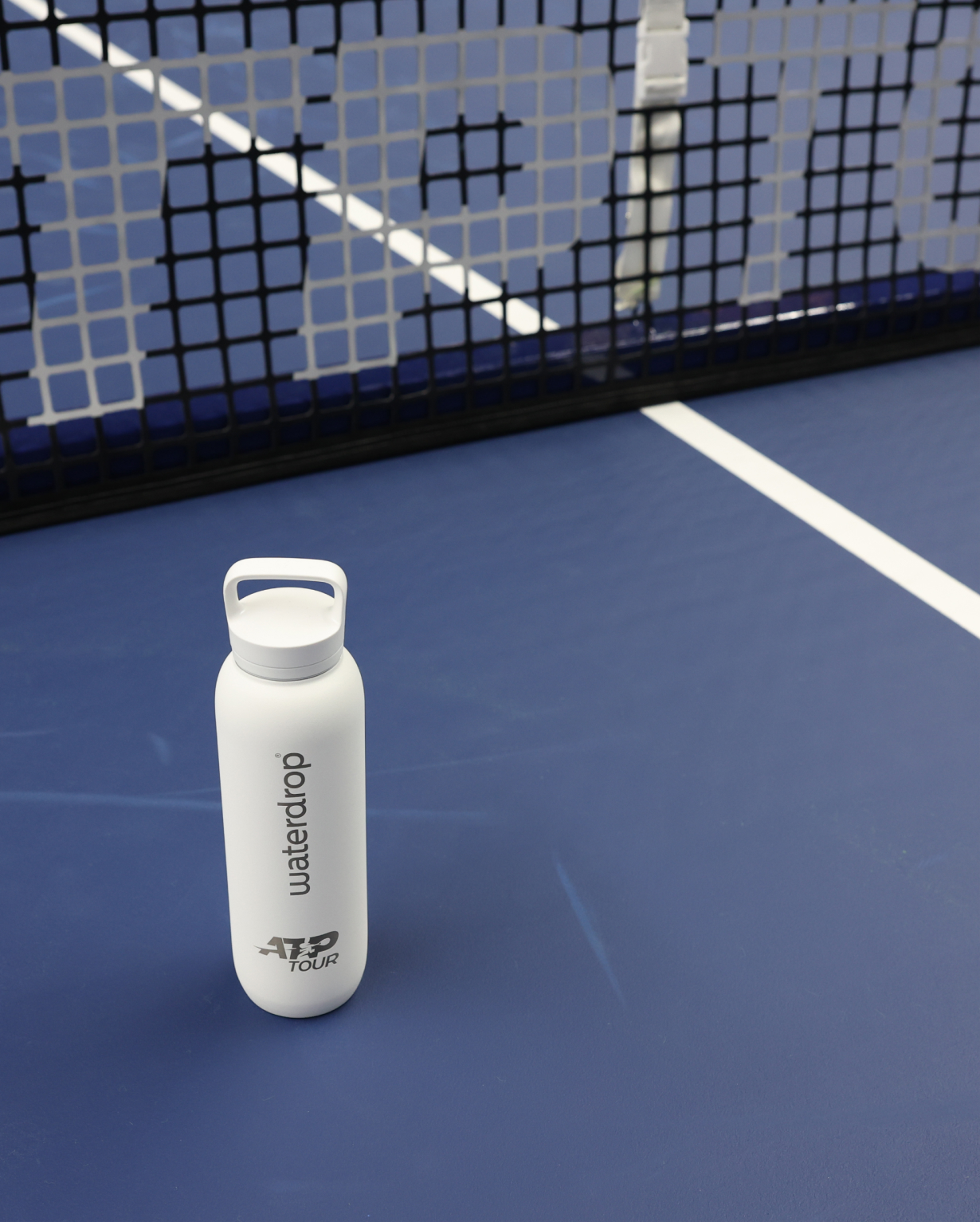 Official ATP Tour All-Purpose Thermo · Spout Lid on tennis court, designed for professional players, featuring co-branding and ice cube compatibility for optimal hydration.