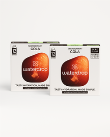 Fizzy Refreshment Twin Pack: Two retail boxes of waterdrop Microdrink® Cola vitamin hydration cubes, 12-serving, zero-sugar, vitamin-enriched, offering cola-flavored hydration.