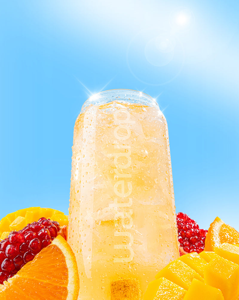 PARADISE FUSION: A frosty glass of fizzy orange-mango drink with condensation, surrounded by fresh fruit slices, capturing a tropical essence under sunny skies.