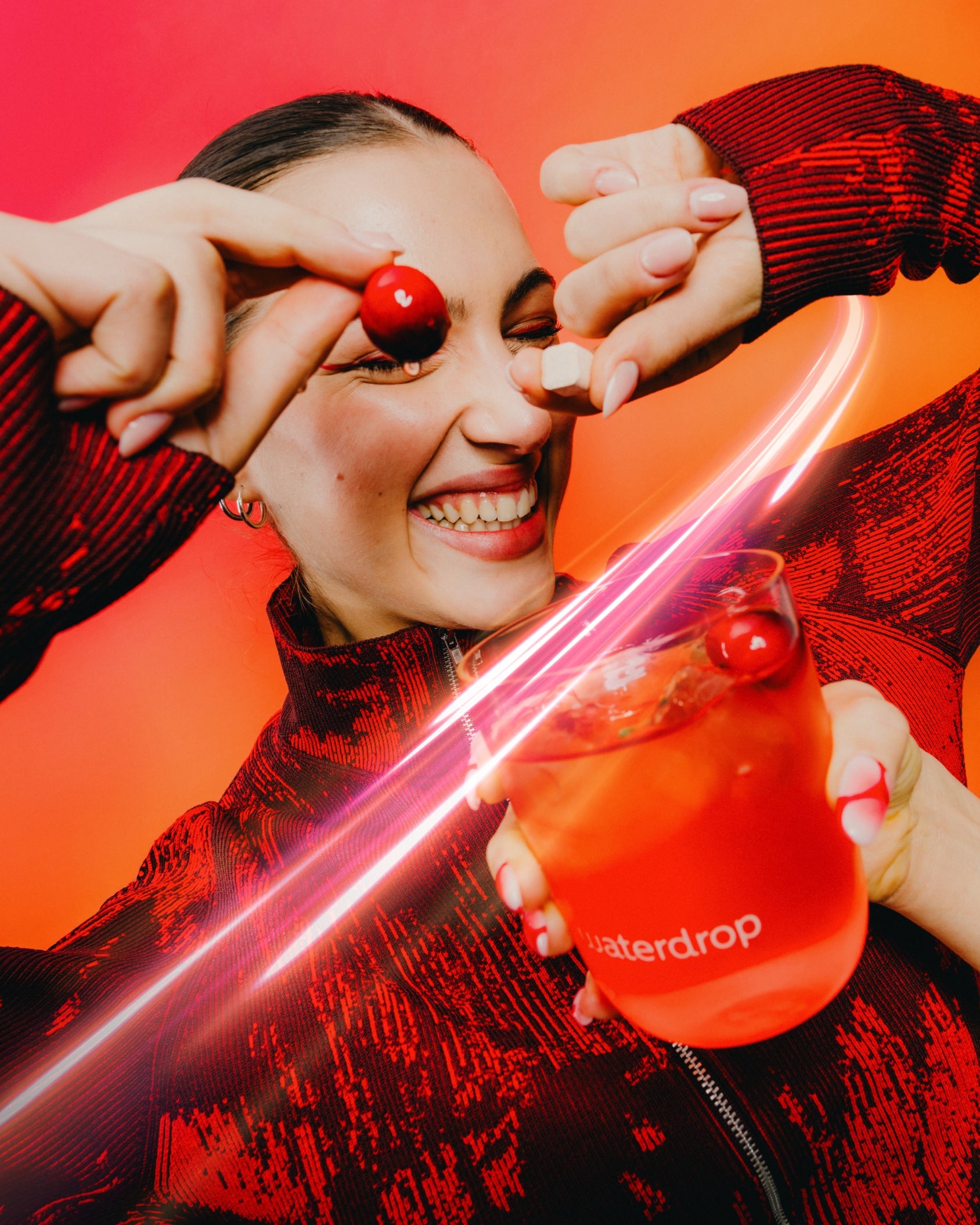 Close-up of a smiling person holding Microenergy BOOST Twin Pack with a glass, highlighting the energy-boosting potential of BERRY BOOST, CHERRY BOOST, or MANGO BOOST flavors.