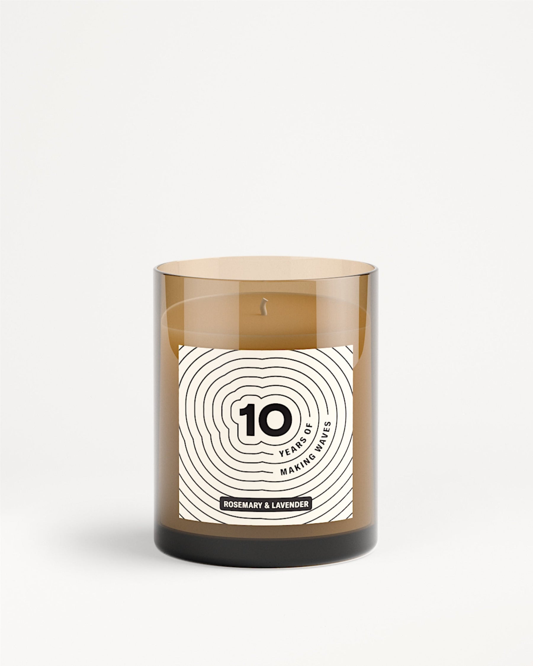 Brown glass candle jar with a white label featuring a concentric circle design.
