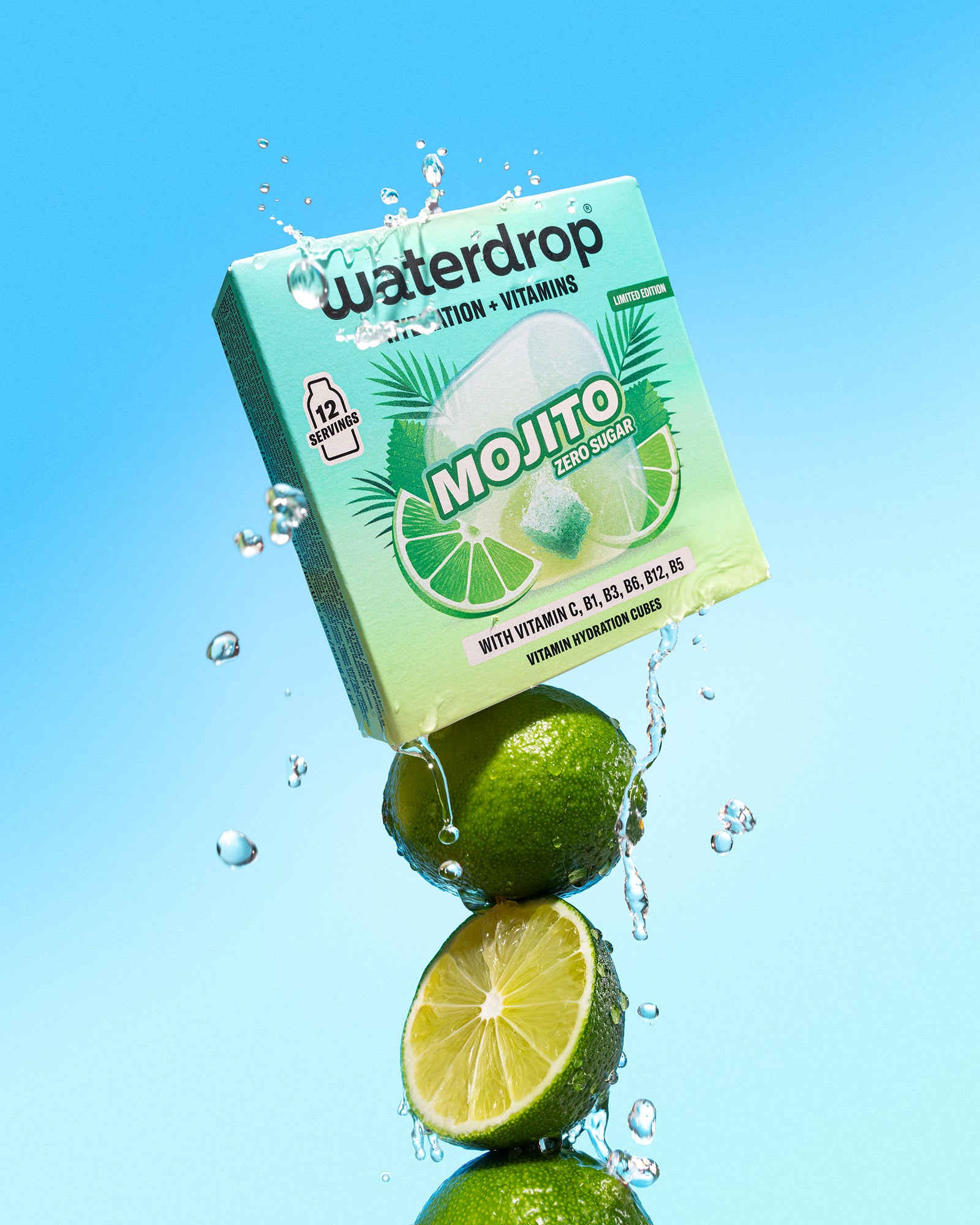Limes stacked beneath a mint-green beverage box with water splashes against a blue background.