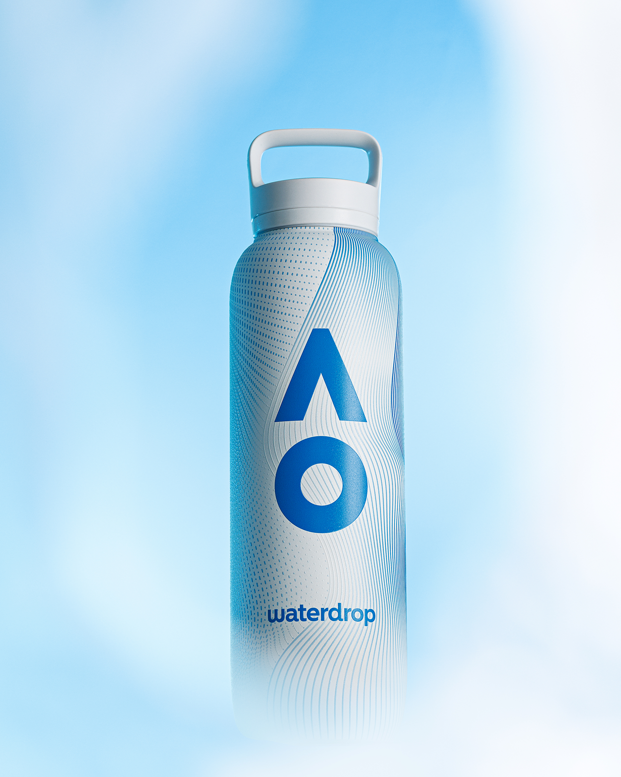 Blue reusable water bottle with a large white geometric logo on the front against a blue misty background.