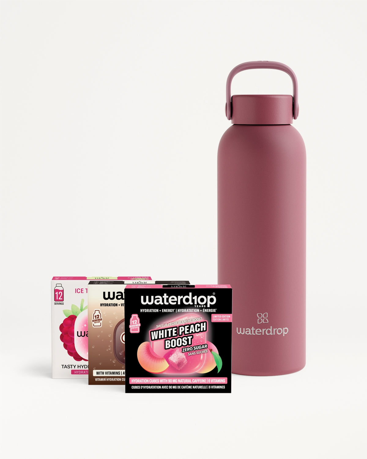 Matte pink insulated water bottle with a loop handle, accompanied by several flavor sachet boxes in front.