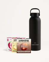 Black insulated water bottle with a carrying handle beside a set of flavor drop boxes.