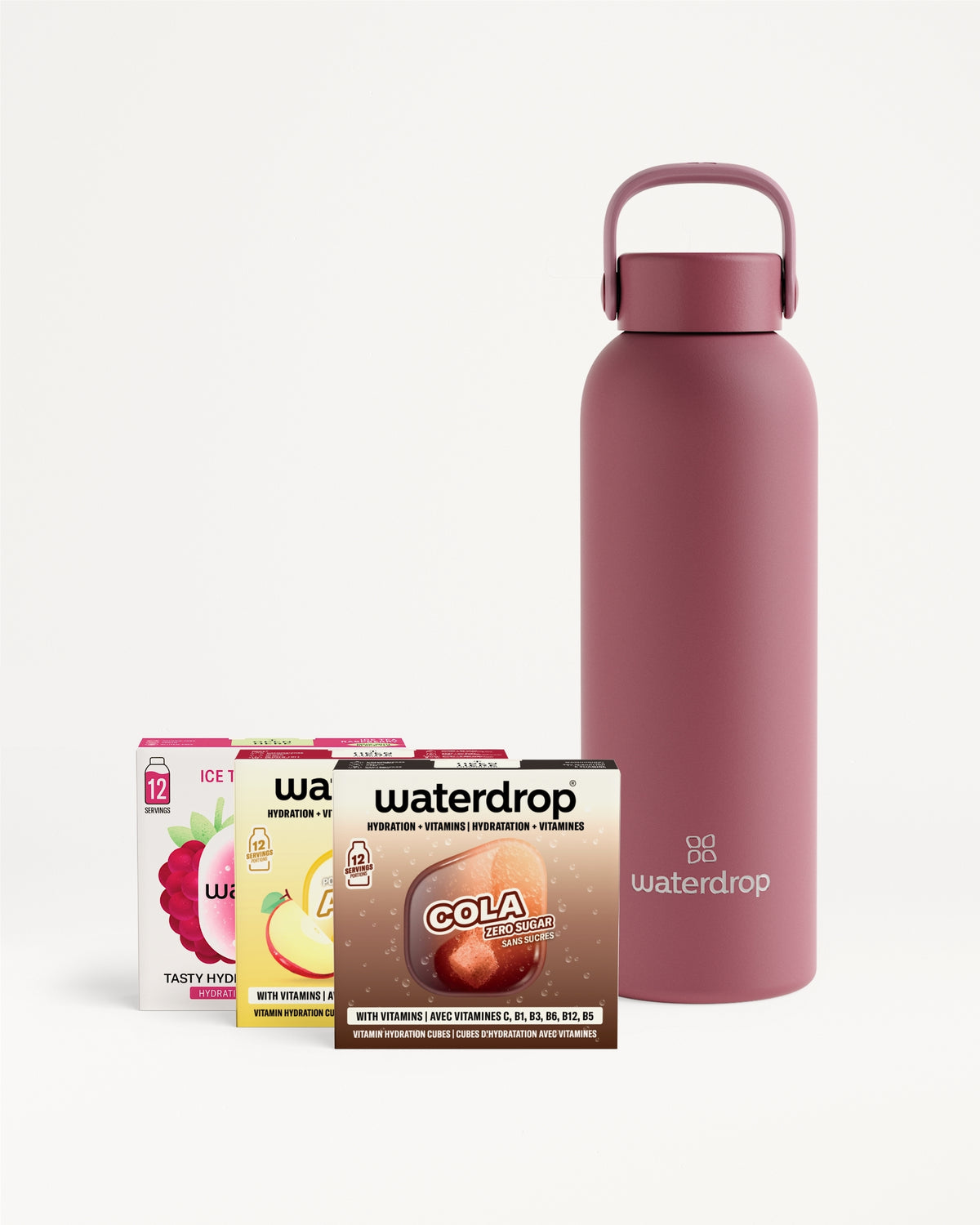Pink reusable water bottle with a loop handle beside assorted drink-mix sachets.
