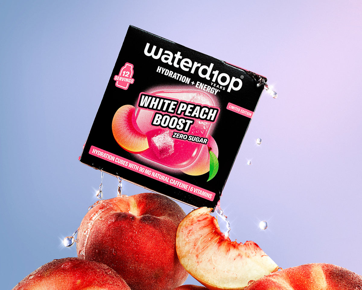 Boxed hydration- and energy-boosting product perched on peaches with water droplets, against a pink-to-blue gradient background.