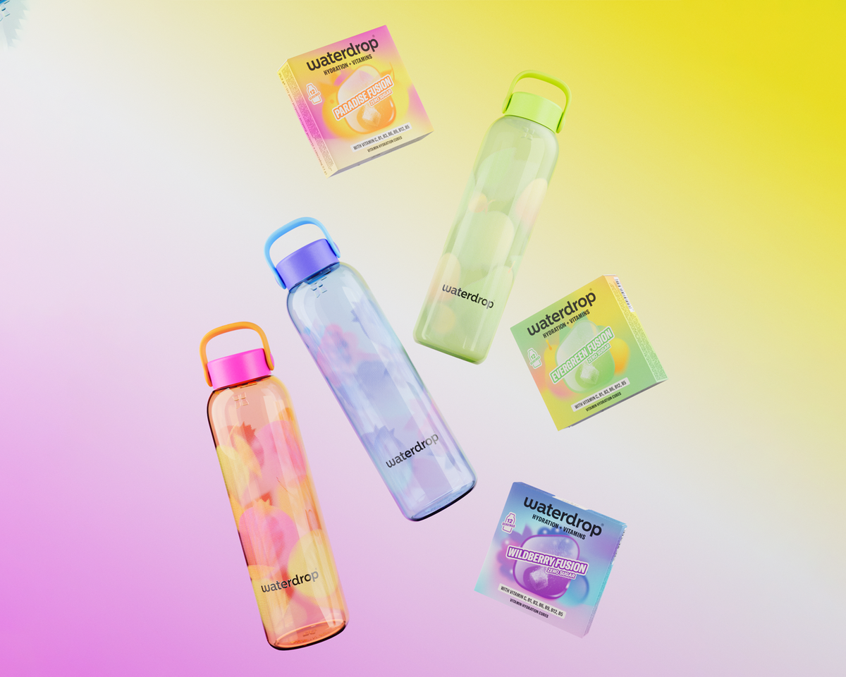 Set of four translucent reusable water bottles with colorful caps on a pastel gradient background, shown with their small boxed packaging.