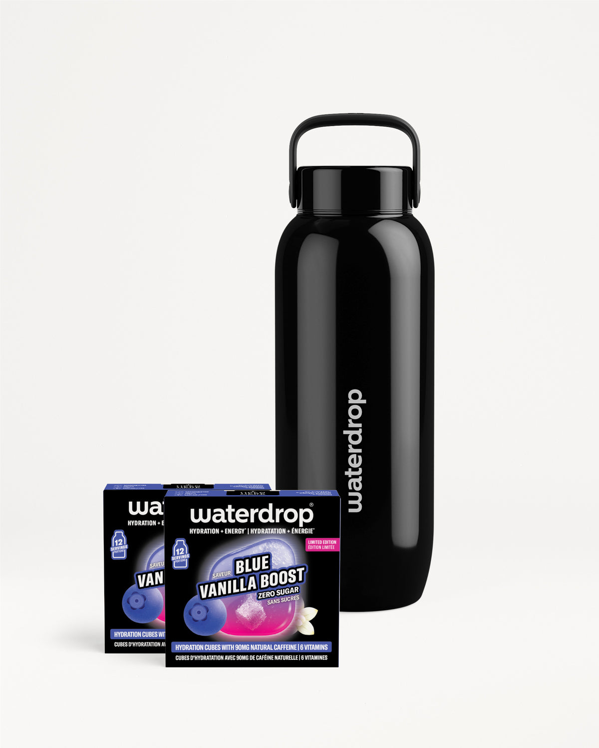 Matte black reusable water bottle with a handle beside two flavor sachets.