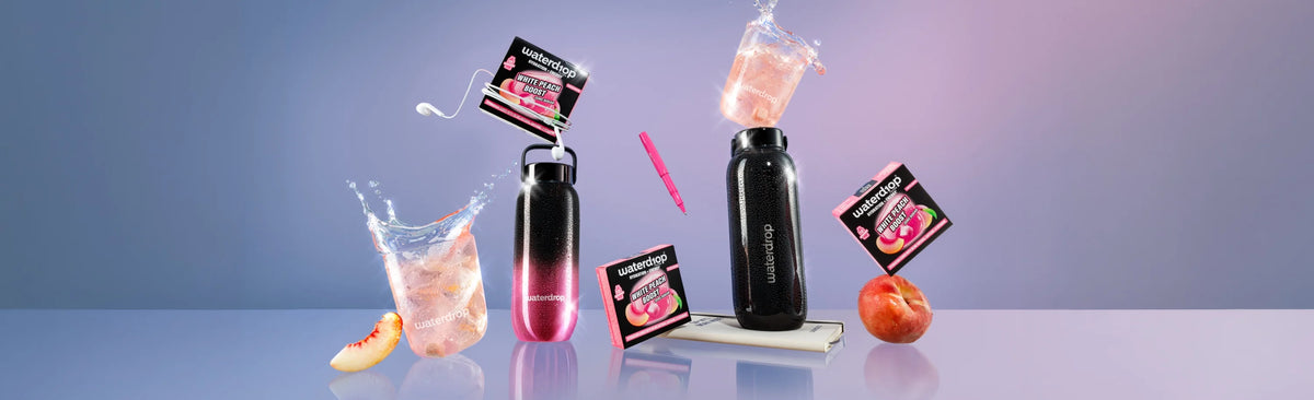 Collection of black bottles with pink liquid and small product boxes scattered on a pastel blue surface.