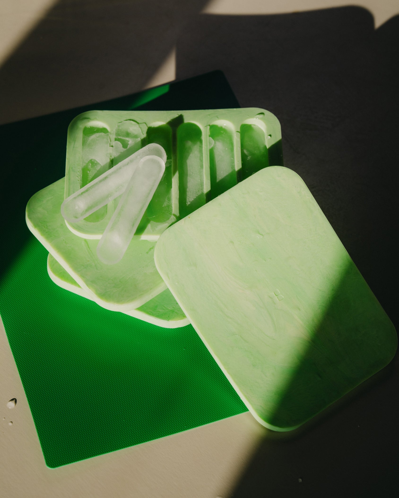 Ice Tray with six ice sticks stacked on a green mat, ideal for perfectly chilled Microdrink.